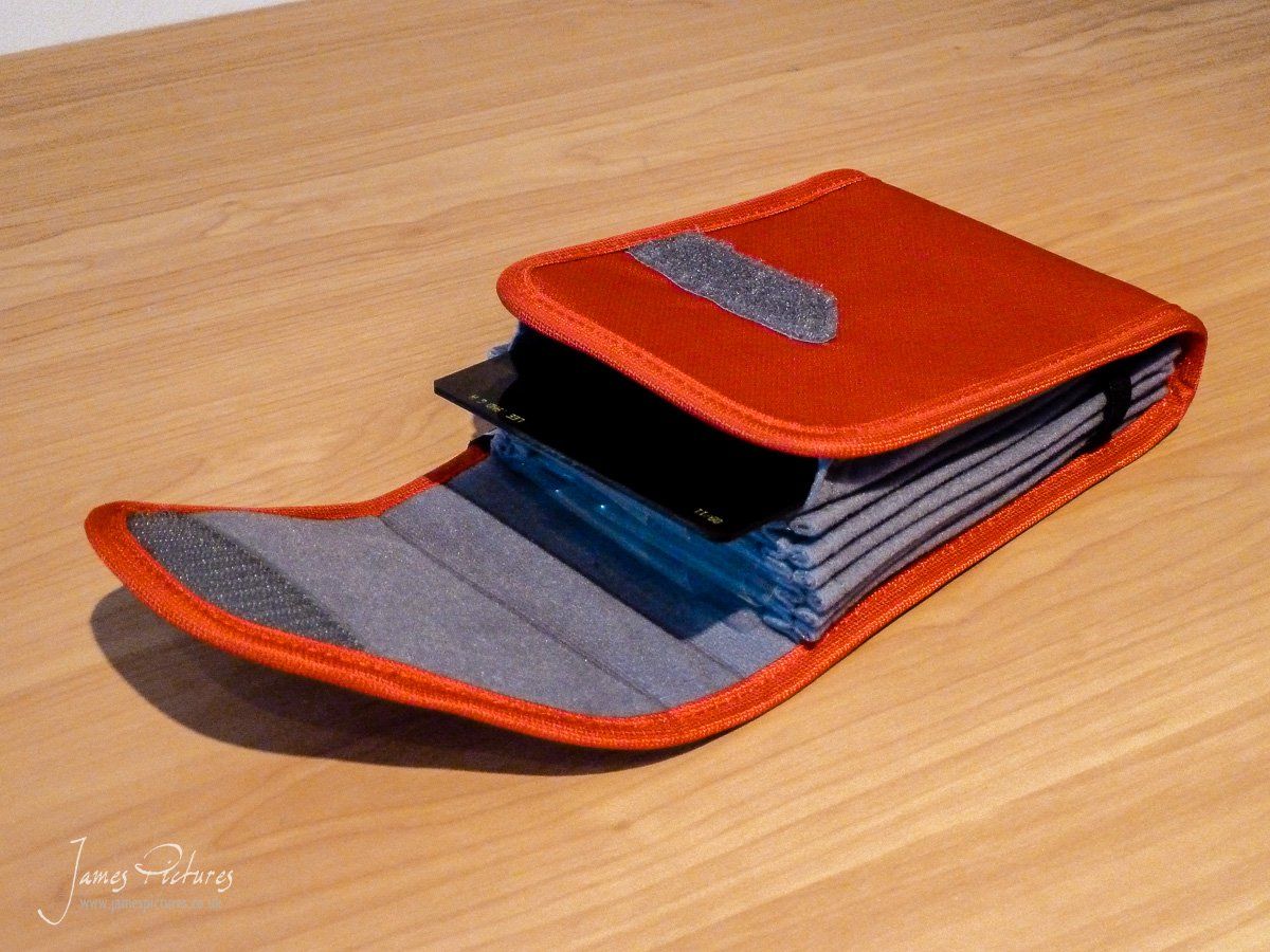 The CliK Elite 7 Filter Holder open with a filter being introduced to one of its sleeves.