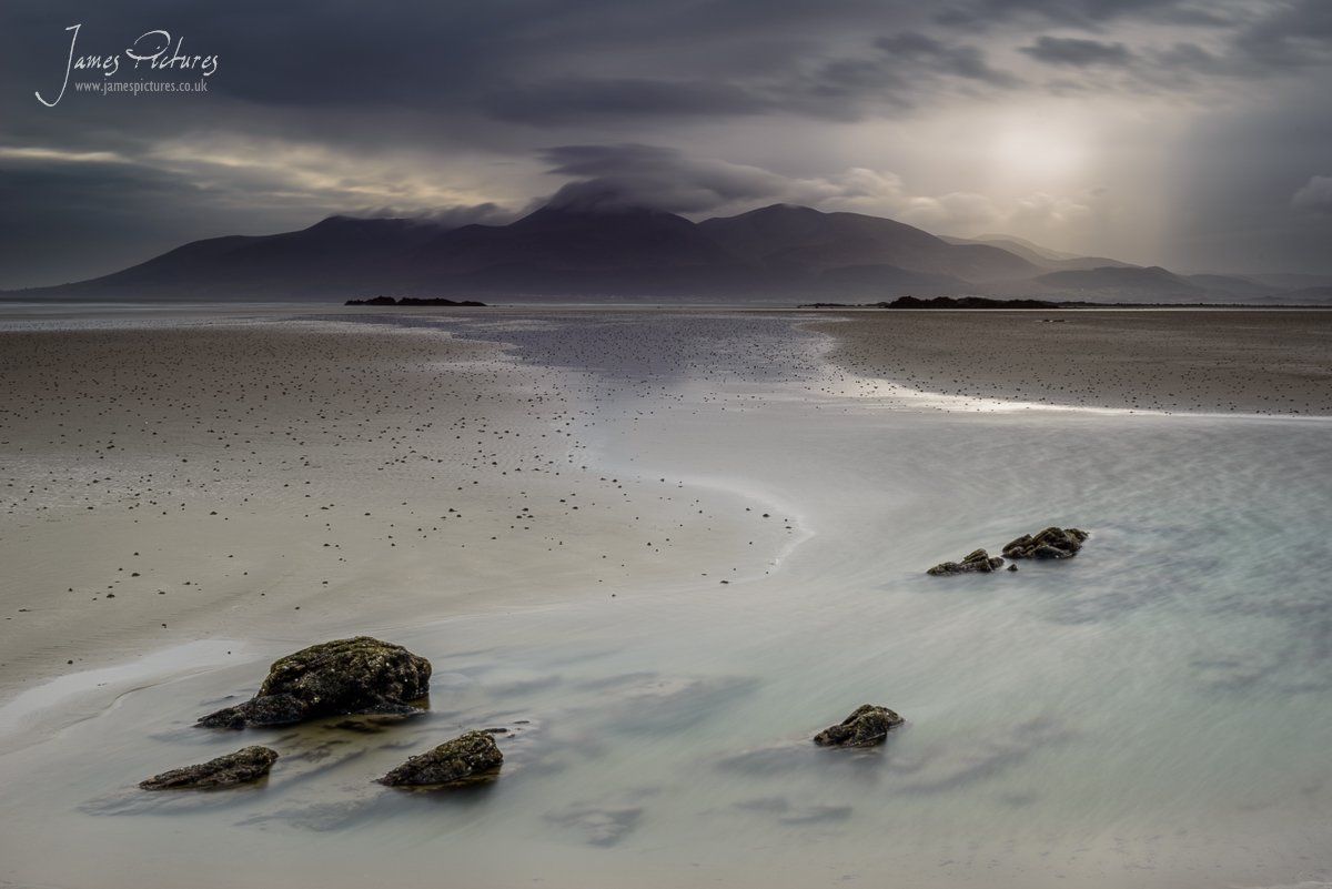 Taken from Tyrella Beach in Downpatrick, Northern Ireland. The Mourne Mountains in the far distant as the light breaks though the clouds.