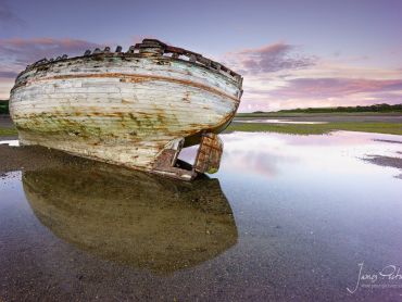 An old stranded vessel in Dulas Bay in Anglesey taken on a September evening as the sun set behind me.