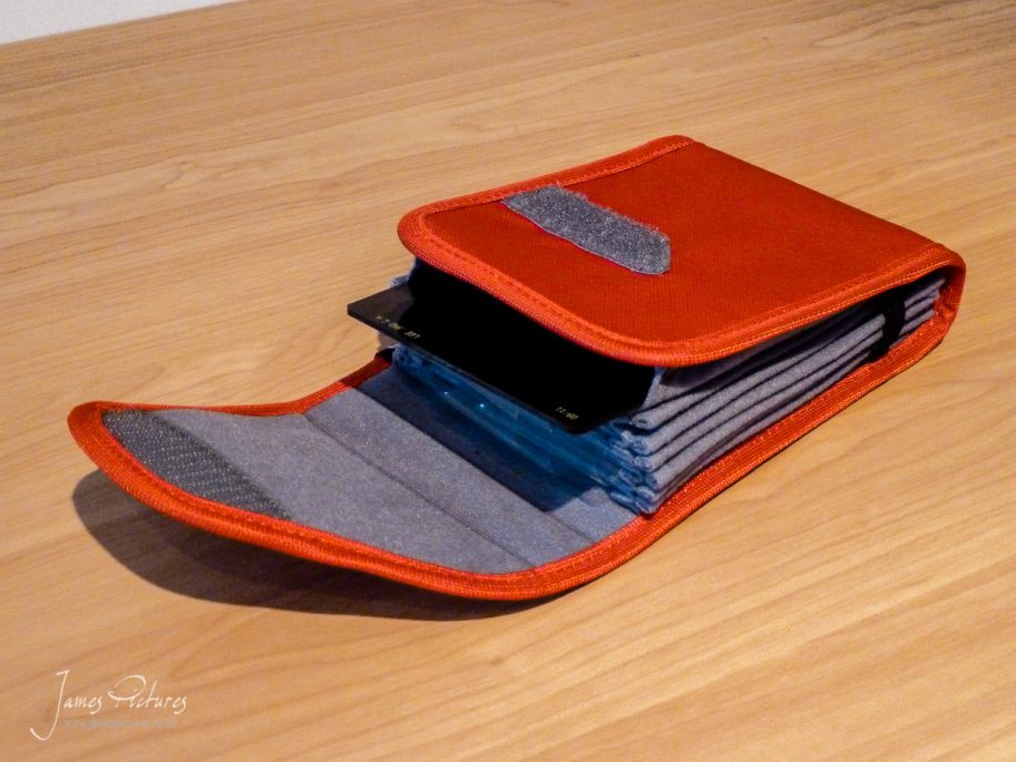 The CliK Elite 7 Filter Holder open with a filter being introduced to one of its sleeves.
