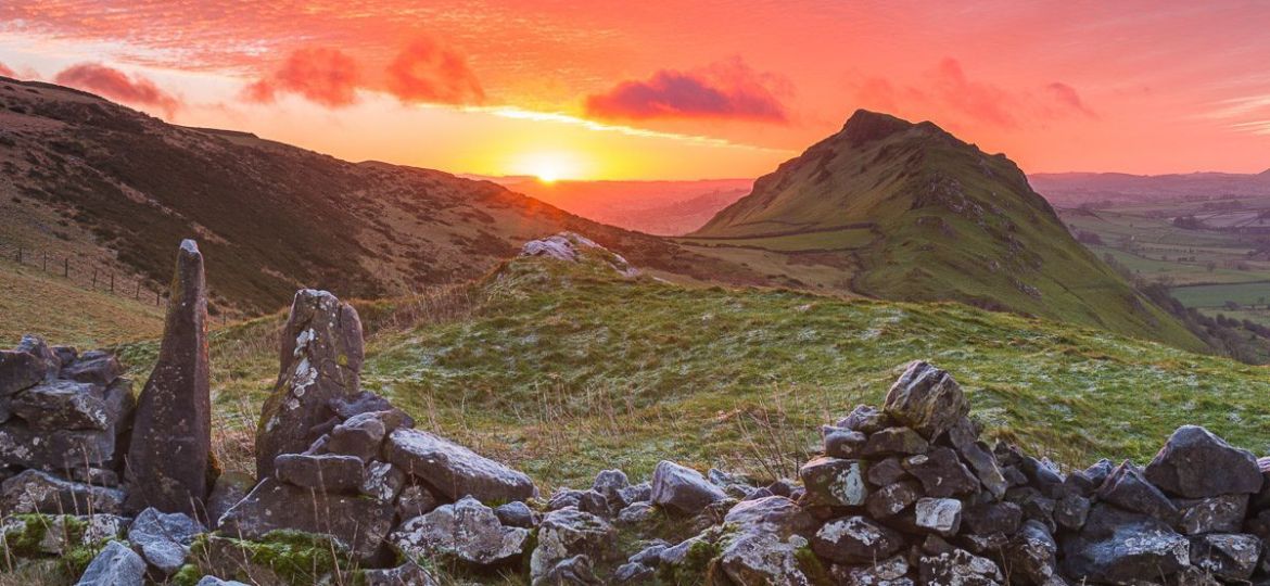 The sun rises over the horizon looking across towards Chrome Hill in the Peak District